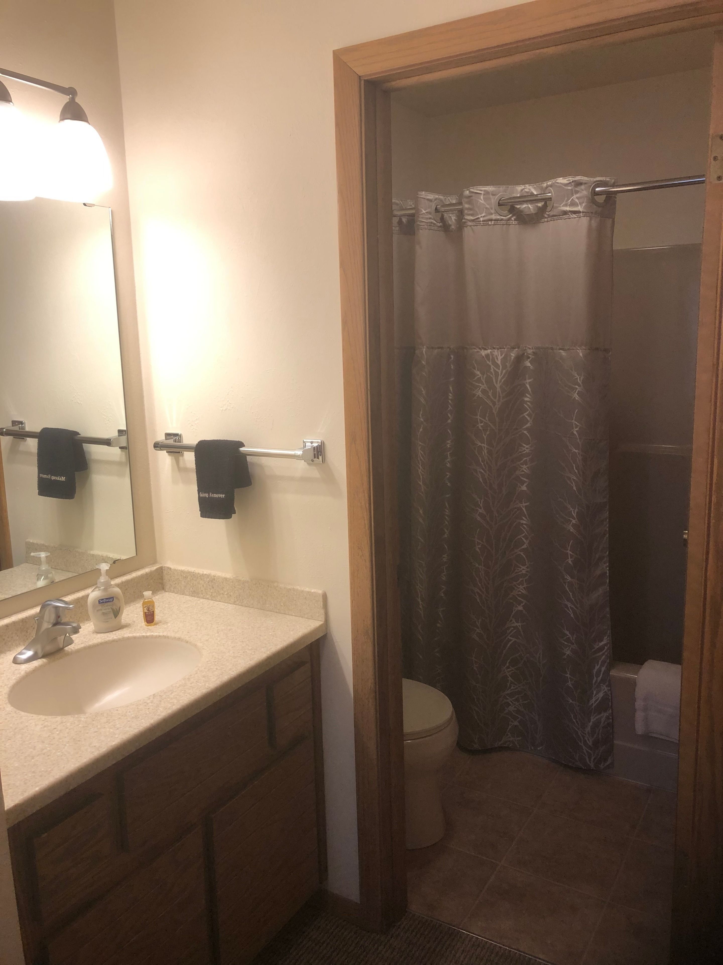 A bathroom with a sink, mirror, and towel rack.