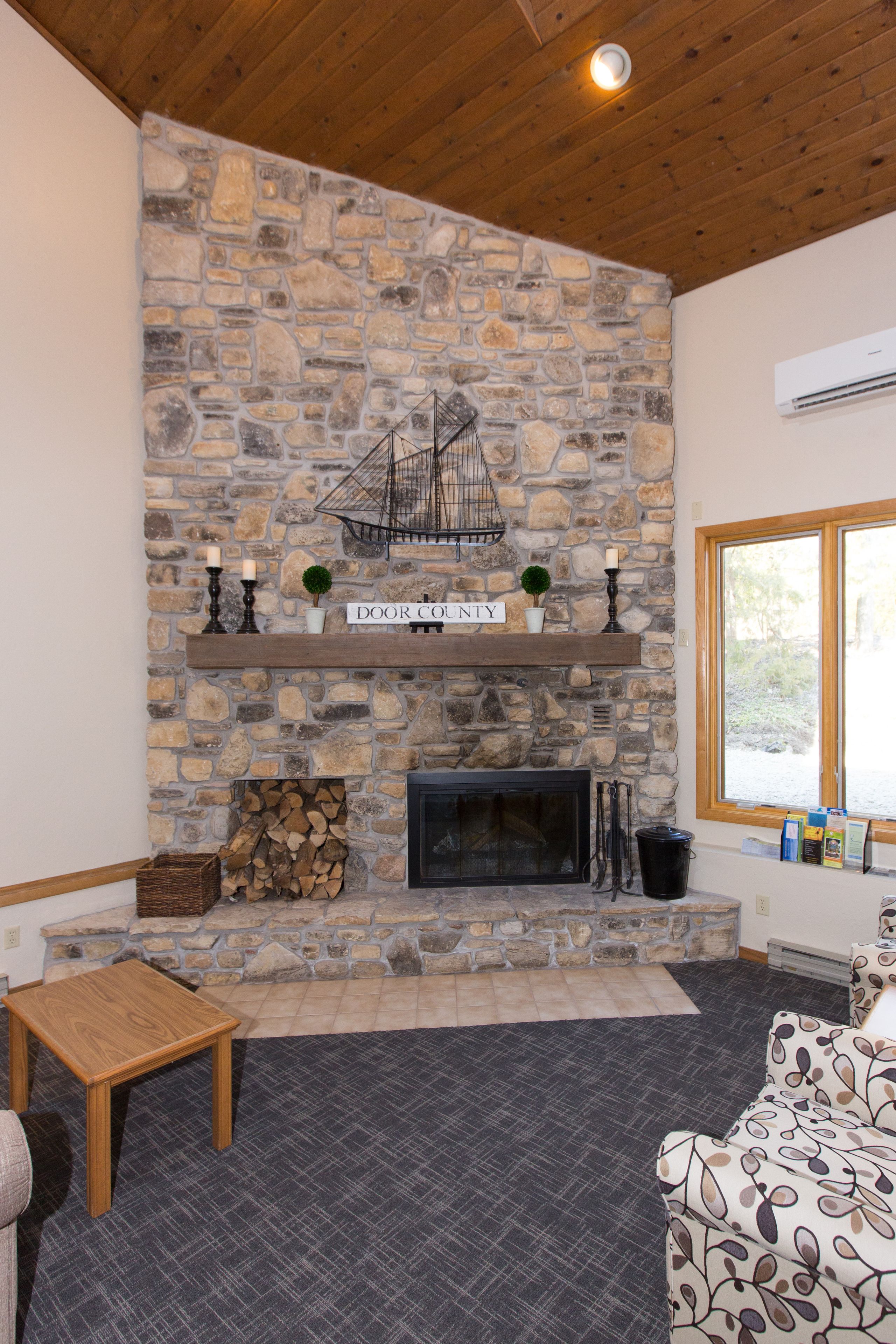 Una chimenea de piedra con una decoración náutica, una repisa de madera y un letrero que dice "DOOR COUNTY".