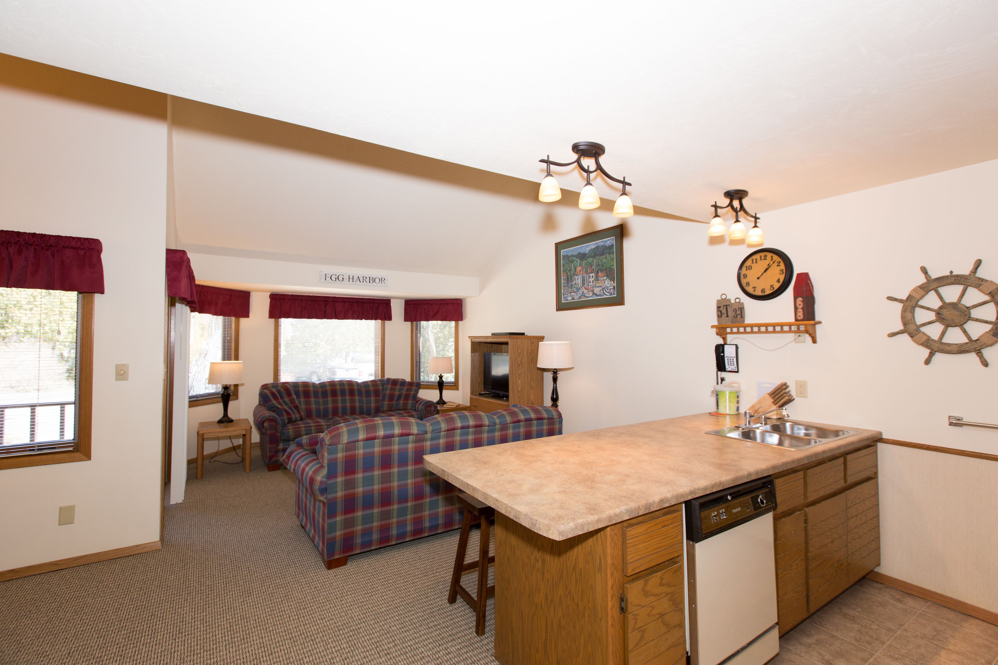 A compact living space with a kitchenette, a sofa, a dining area, and a view of the outside.