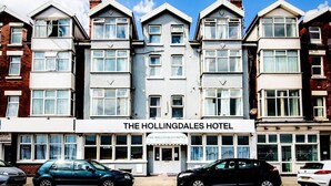 Una hilera de casas adosadas con un edificio central que dice "The Hollingdales Hotel".