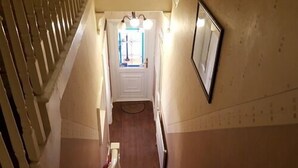 Una escalera que lleva a una habitación con una puerta y un espejo en la pared.