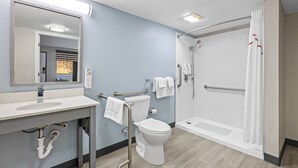 A modern bathroom with a sink, toilet, and walk-in shower. - HomeTowne Studios by Red Roof Athens, TN (Athens)