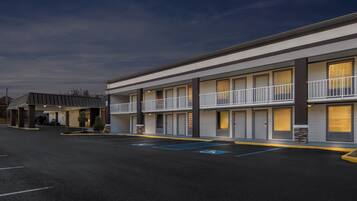 A modern hotel with a two-story structure, multiple rooms, and a parking lot with handicapped parking spaces.