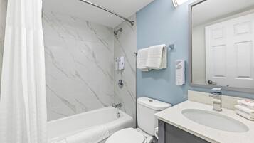 Ein Badezimmer mit Badewanne, Toilette und Waschbecken.