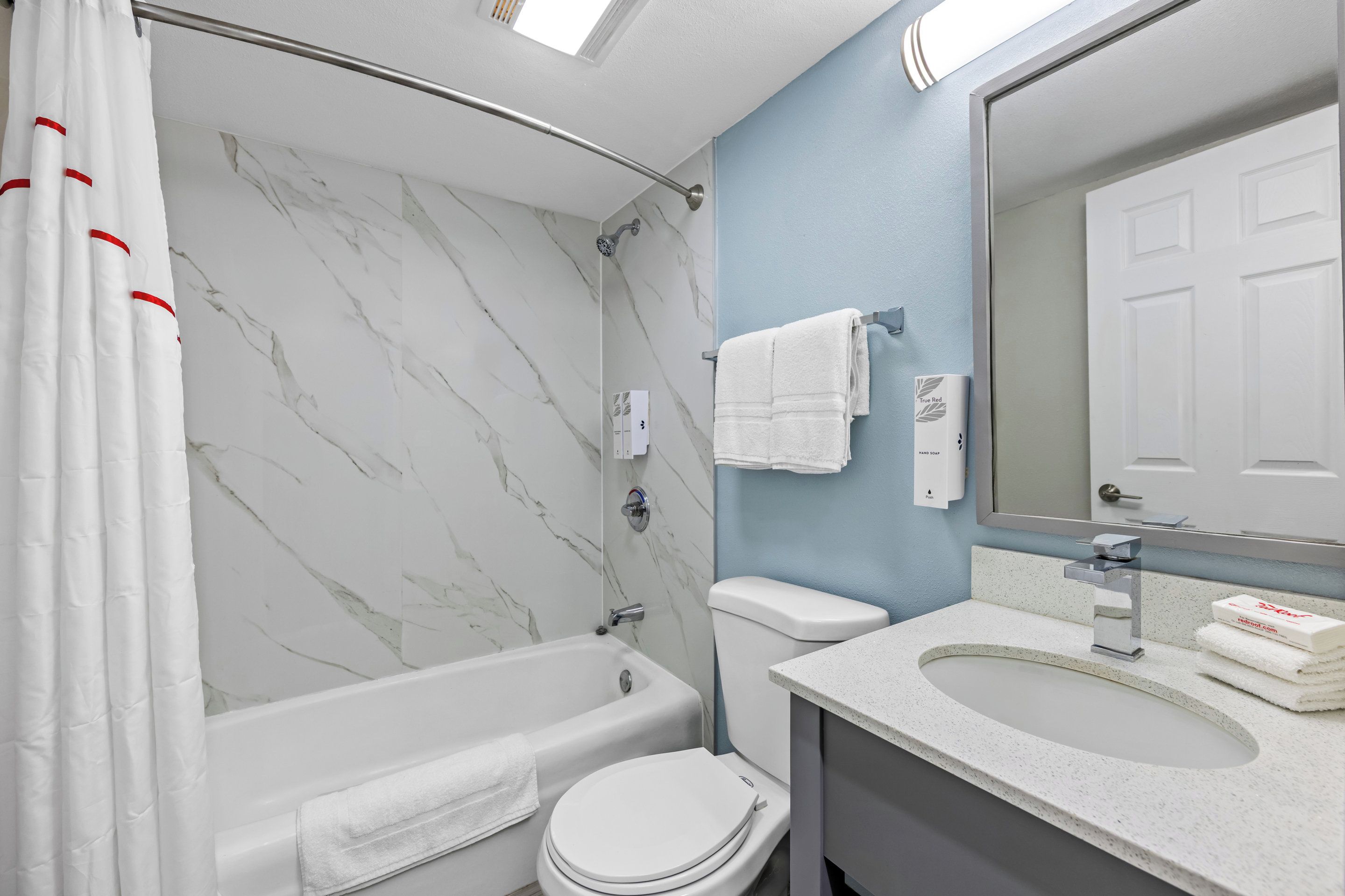 Een badkamer met een bad, toilet en wastafel.