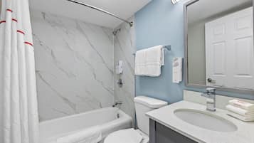 Een badkamer met een bad, toilet en wastafel.