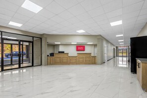 A spacious lobby with a reception desk, a sign indicating free Wi-Fi, and a view of the parking area. - HomeTowne Studios by Red Roof Athens, TN (Athens)