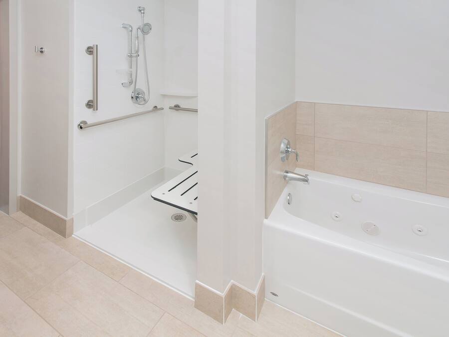 A modern bathroom with a walk-in shower, a bathtub, and a toilet.