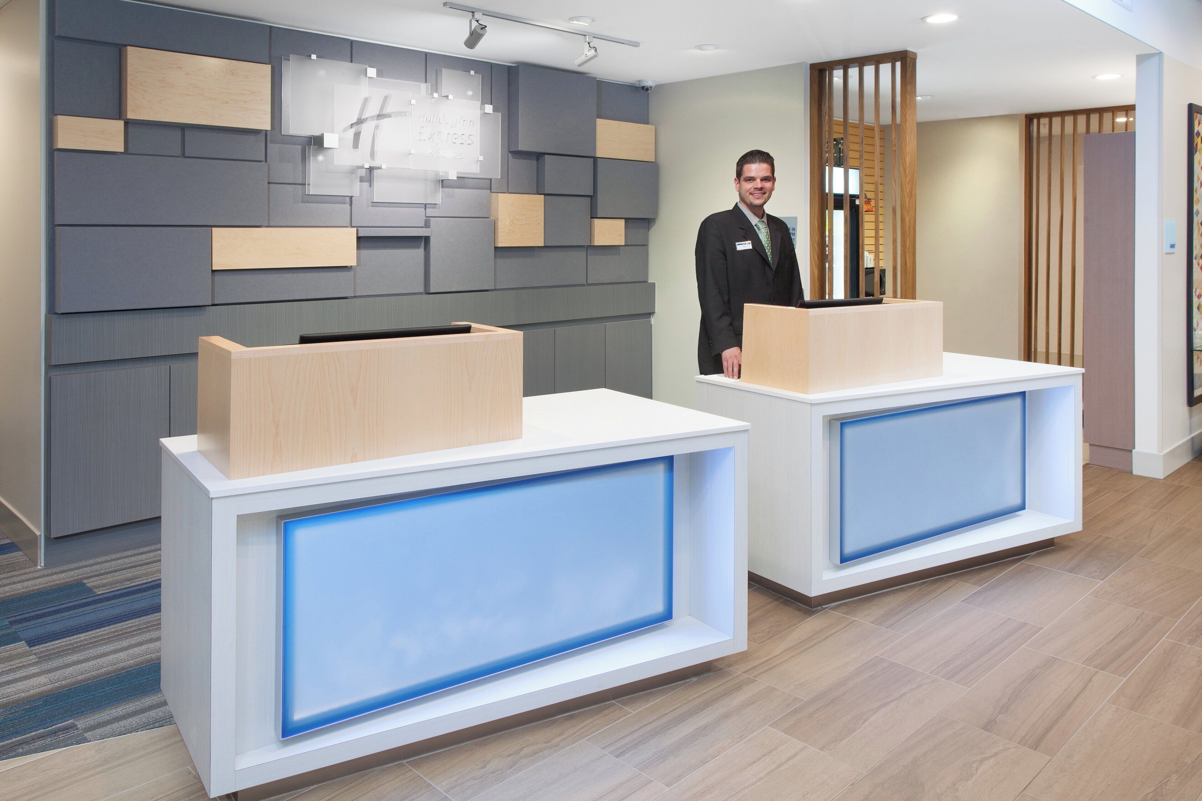 A reception area with two reception desks, a wall-mounted sign, and a wooden partition.