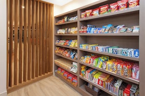 Un pasillo con diversos snacks envasados y una puerta de madera con listones.