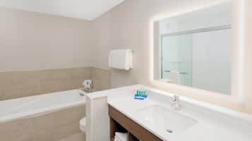 Ein modernes Badezimmer mit einer Badewanne, einem Waschbecken und einem großen Spiegel.