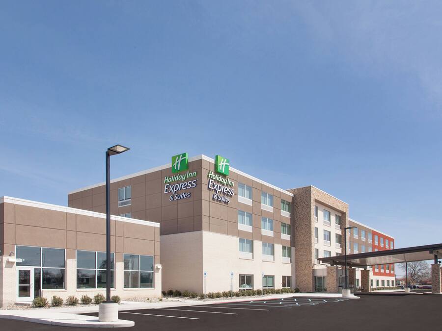 Un hôtel Holiday Inn Express & Suites au design moderne, avec une façade en briques et de grandes fenêtres.