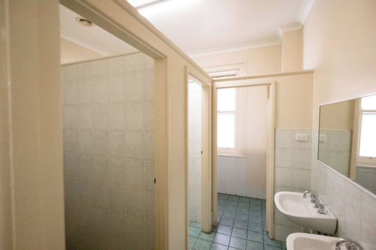 A bathroom with a tiled floor, a sink, and a mirror.