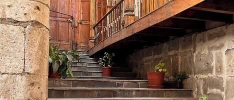A stone staircase with wooden railings and potted plants.