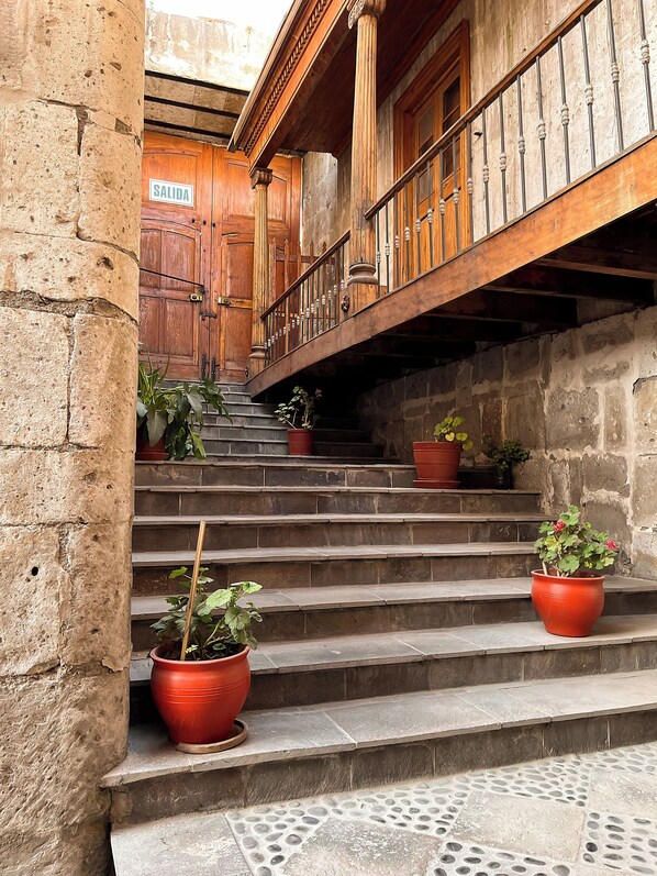 A stone staircase with wooden railings and potted plants.