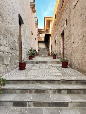 A narrow stone staircase leading up to a building with wooden balconies. - Tambo del Solar Hotel (Arequipa)