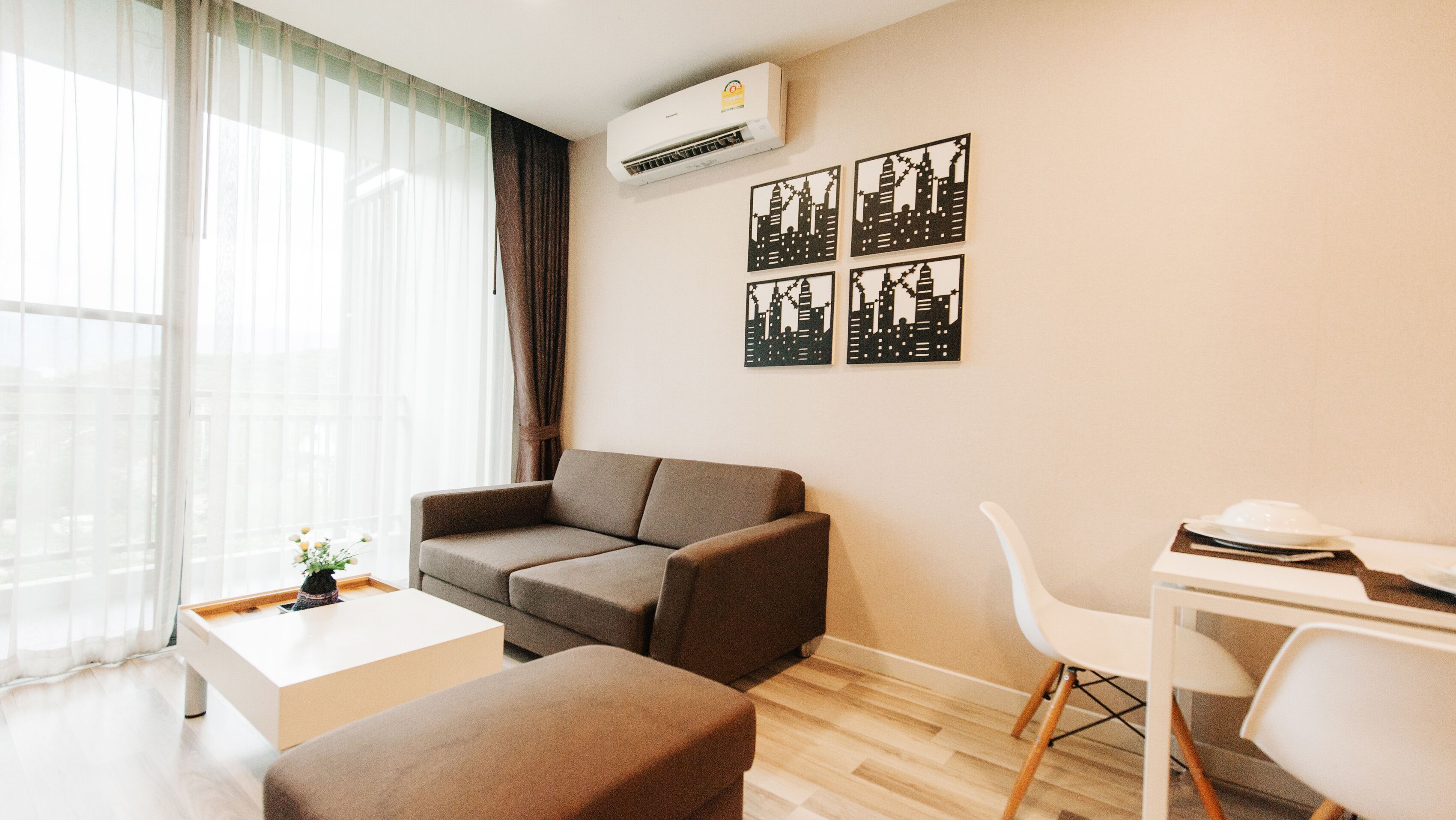 A modern living room with a sofa, a coffee table, and a dining area with a chair and table.