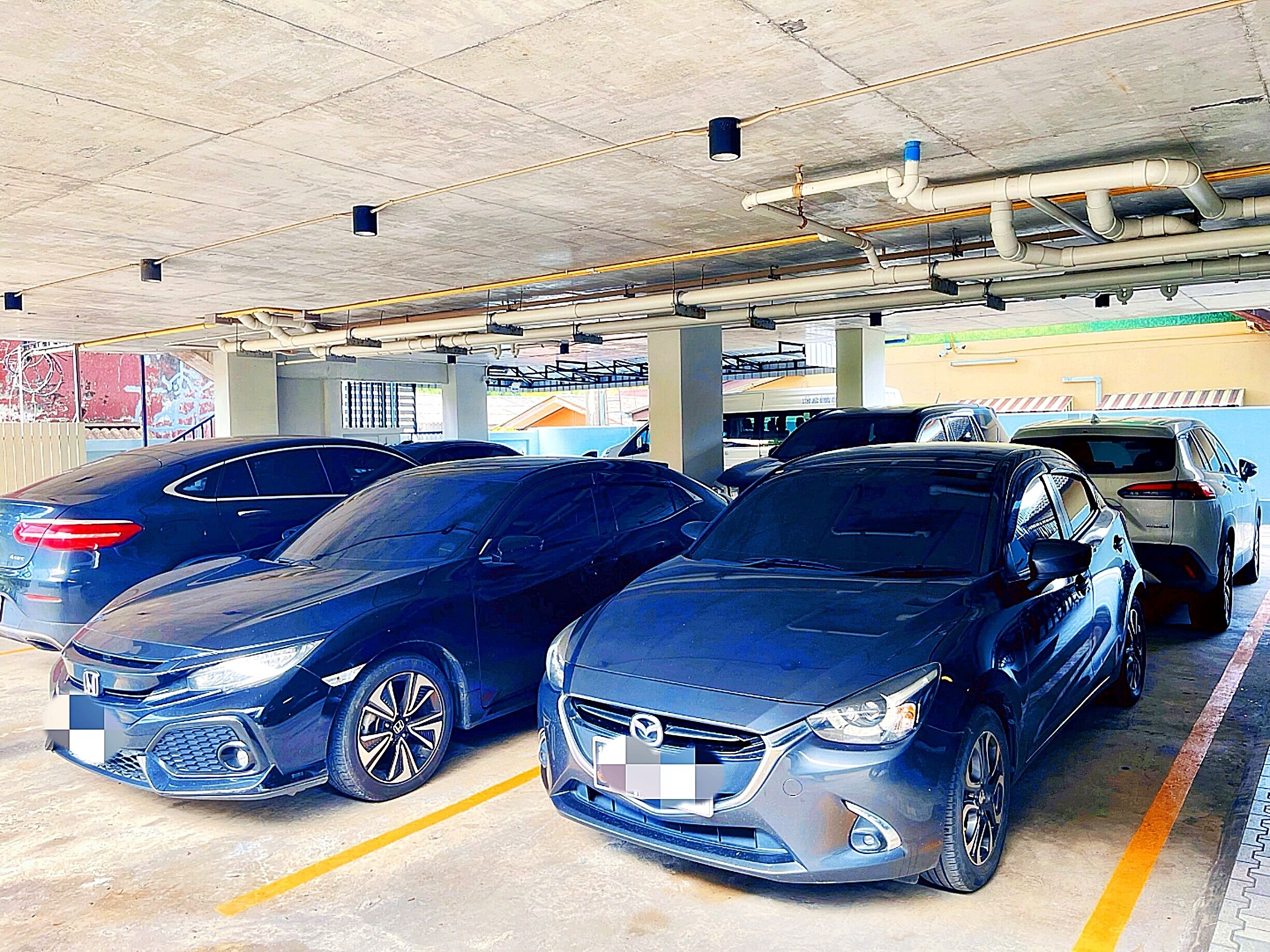 Un garaje para estacionamiento con varios coches aparcados en sus lugares designados.