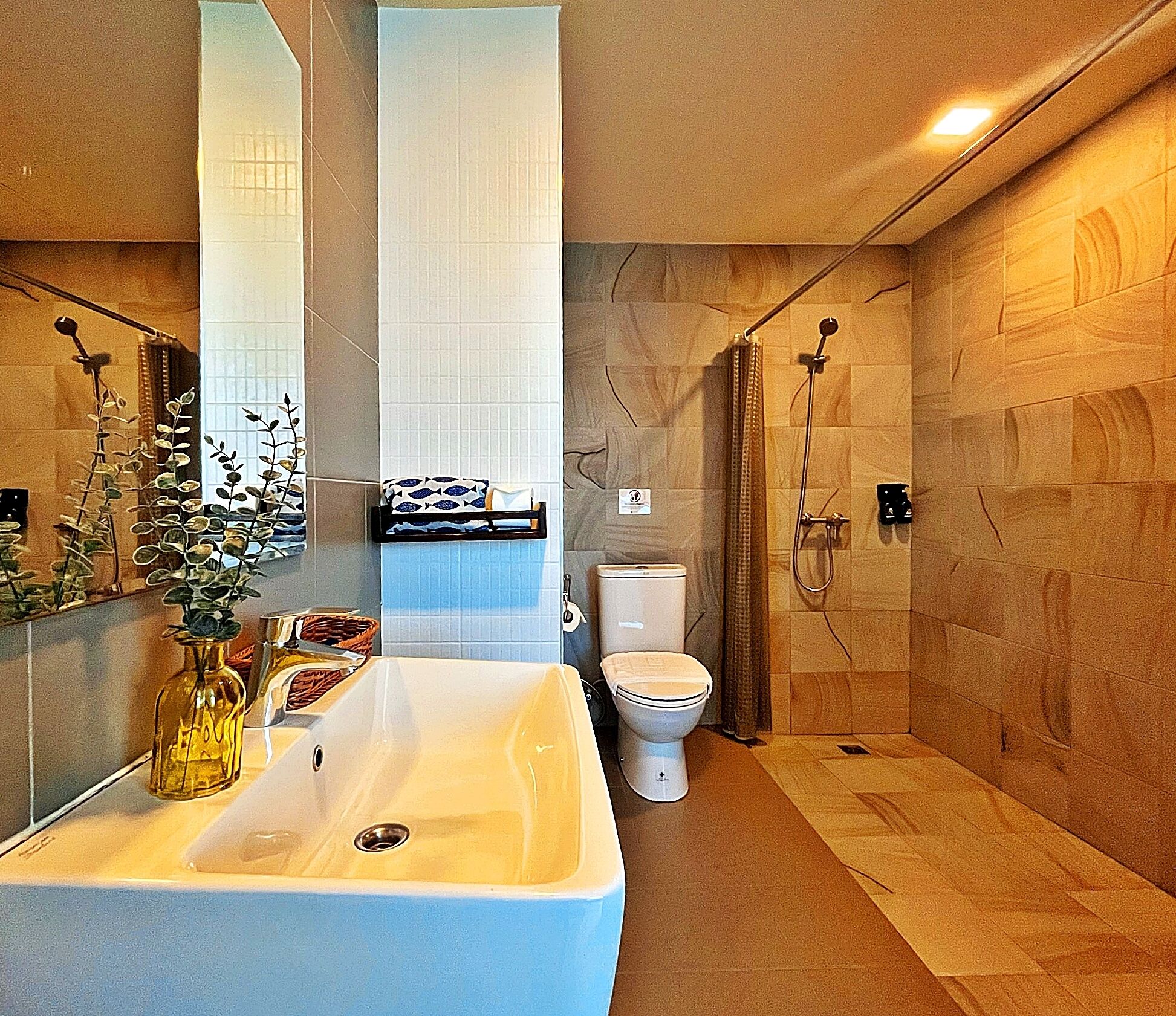Un baño moderno con un lavamanos grande, inodoro y ducha.