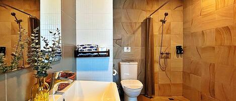Un baño moderno con un lavamanos grande, inodoro y ducha.