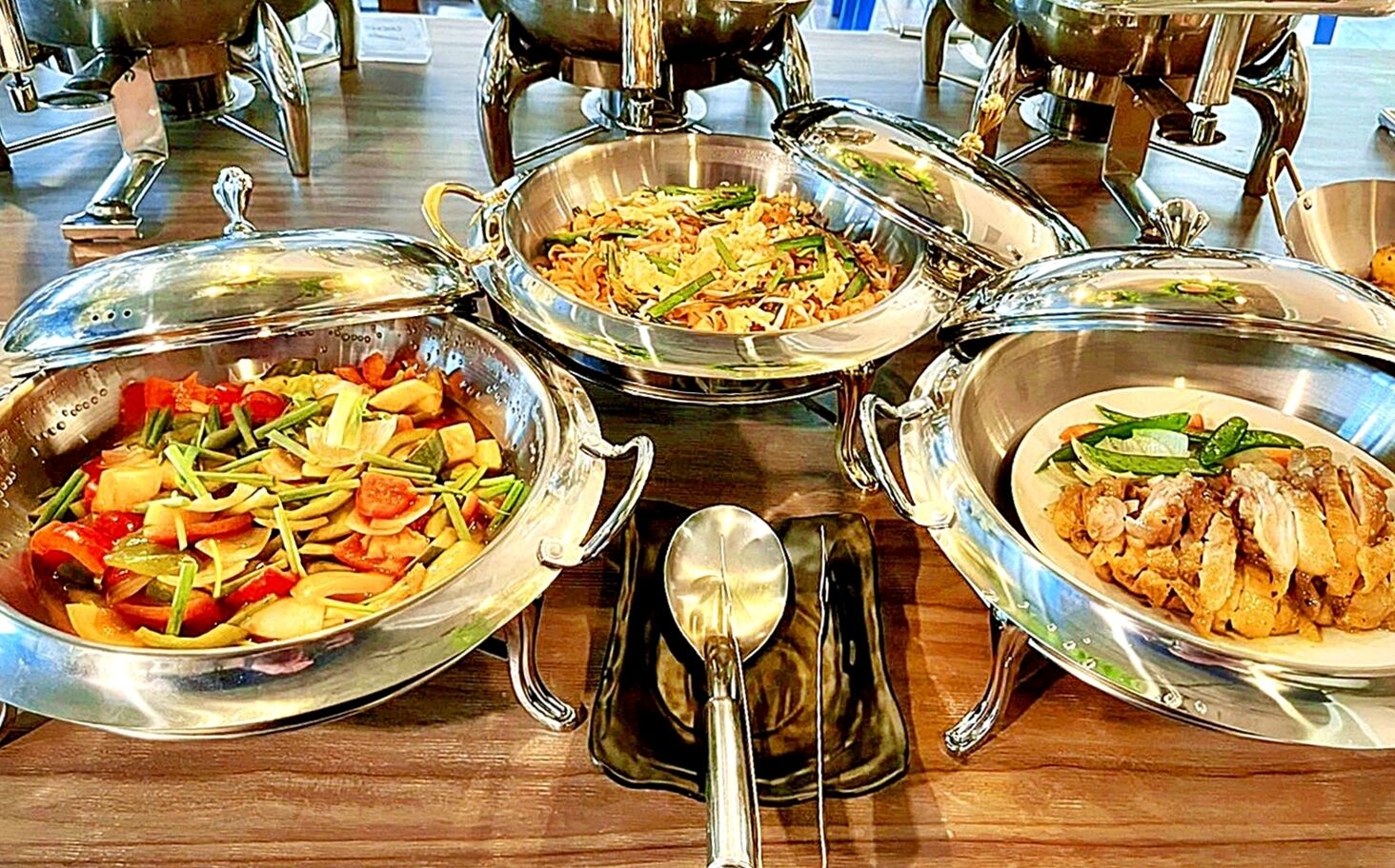 Ein Buffet mit verschiedenen Speisen in Metallservierbehältern.