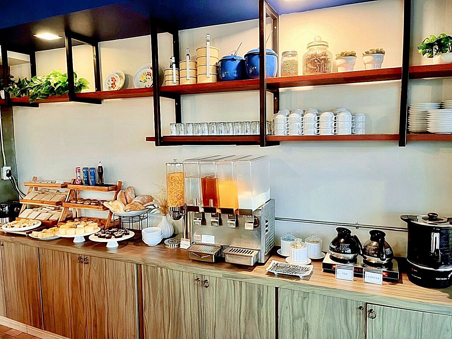 Un bufé de desayuno con diversas opciones de comida y máquinas de café.