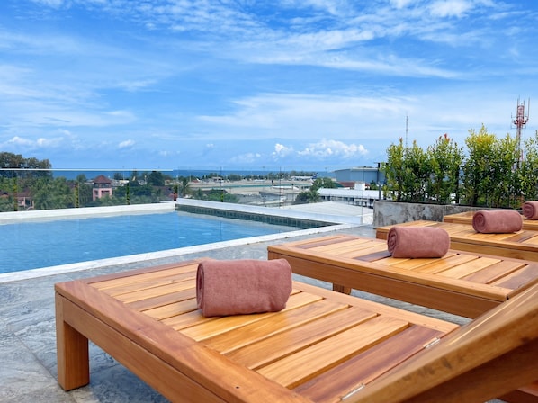 Una piscina al aire libre, tumbonas