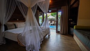 Ein Schlafzimmer mit einem Himmelbett, einem Balkon mit Pool und Holzboden.