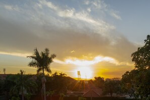 A sunset over a residential area with houses and palm trees. - Jasmine Inn (Kingston)