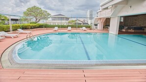 Une piscine avec des chaises longues et une terrasse en bois.