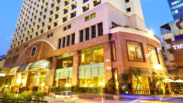 Un grand hôtel au design moderne, caractérisé par une entrée incurvée imposante et de nombreux étages.