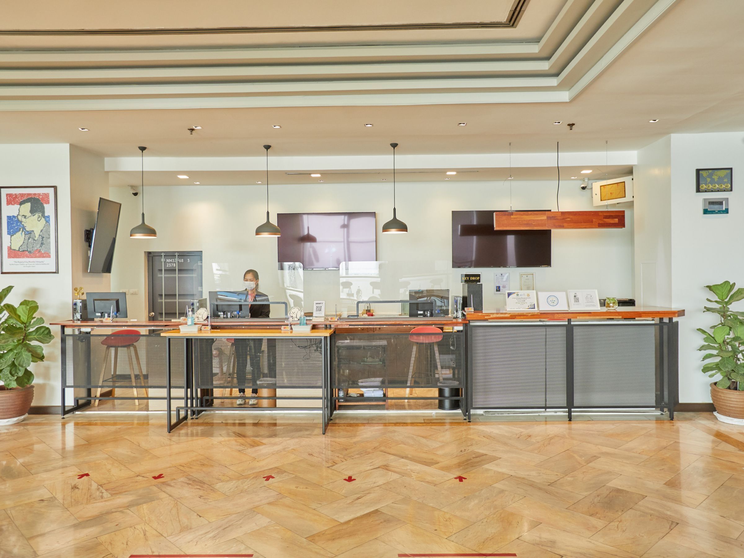 A modern kitchen with a central island, bar stools, and a person working at the counter.