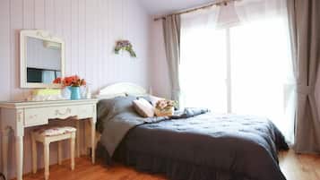 Un dormitorio con cama, cómoda, espejo y ventana con cortinas.