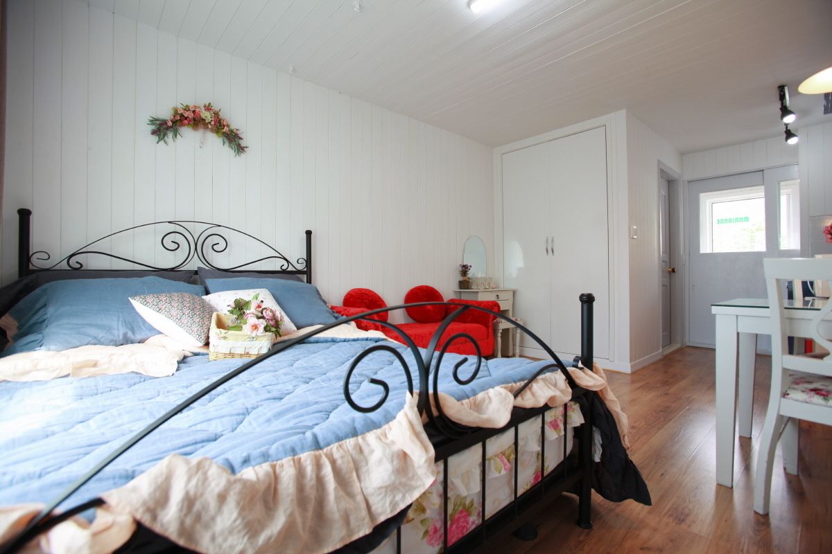 Un dormitorio con una cama, un escritorio y una silla.