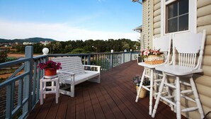 A wooden deck with a white bench and chairs, a railing, and potted plants. - Edelweiss Pension (Pyeongchang)