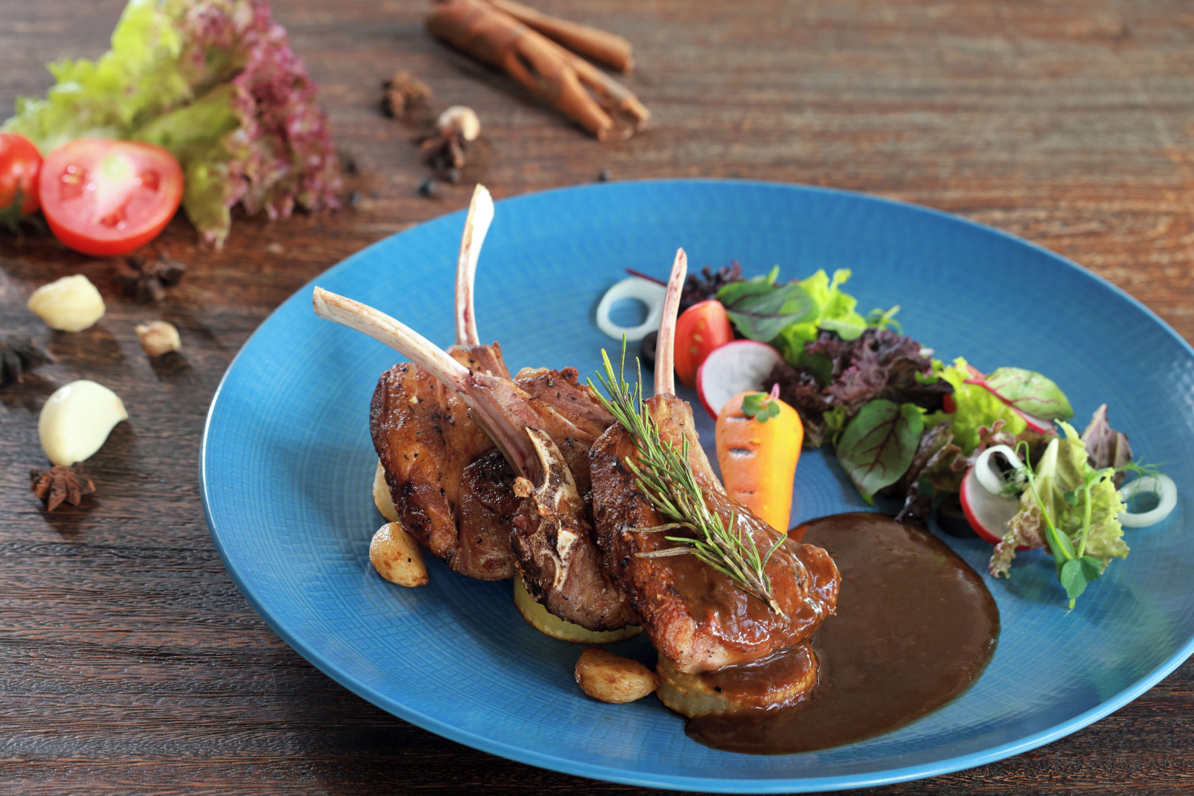 En tallerken med lammechops, grøntsager og en salat.