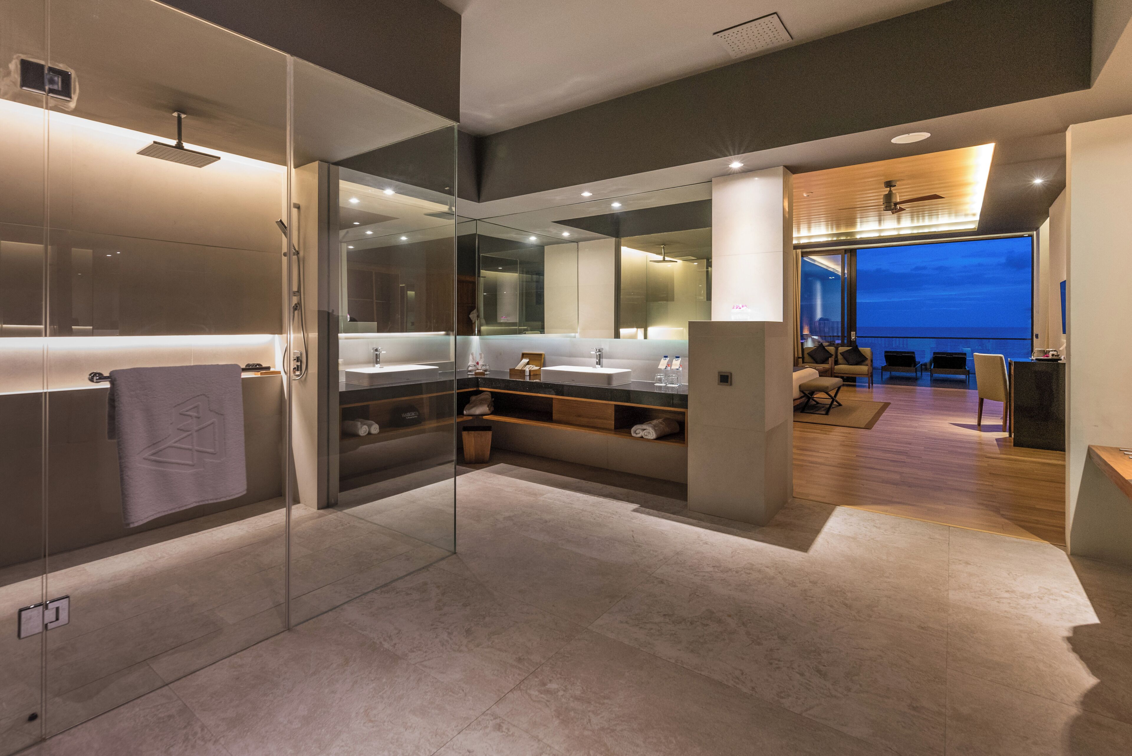 Un bagno moderno con cabina doccia in vetro, uno specchio grande e un mobile lavabo.