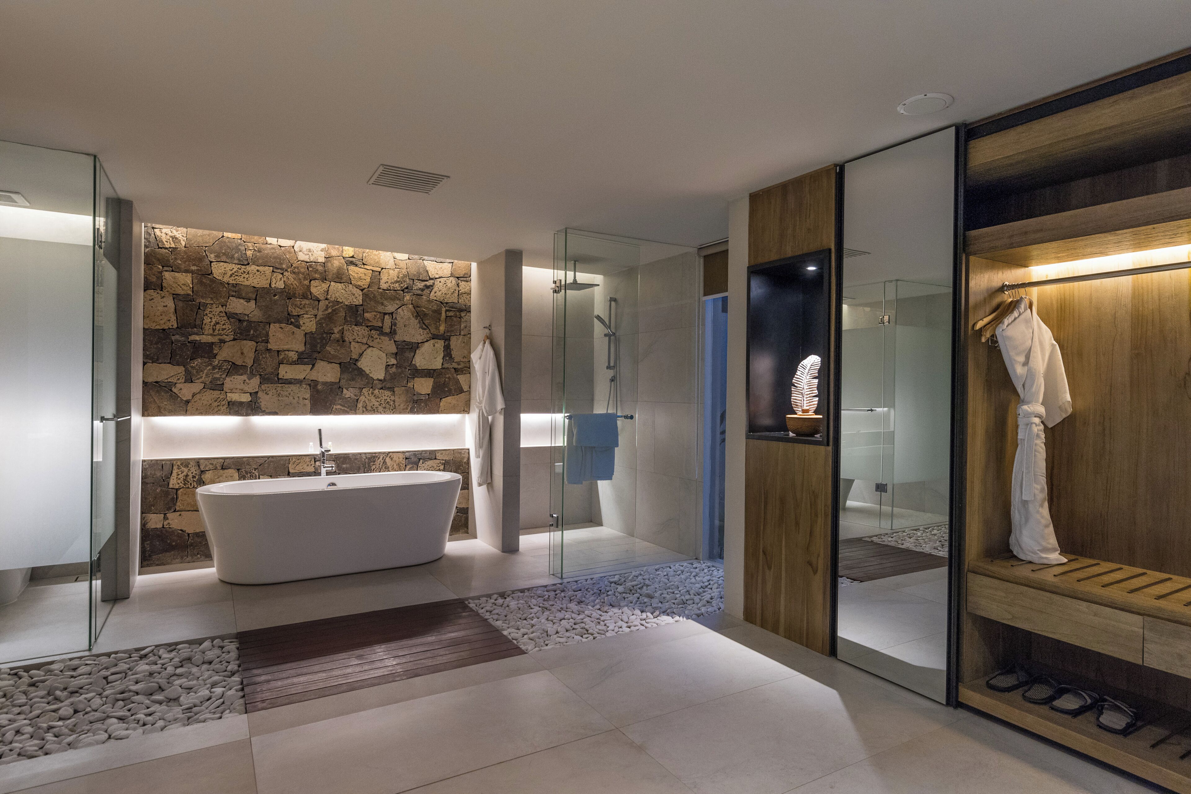 A modern bathroom with a freestanding bathtub, a glass-enclosed shower, and a wooden vanity with a mirror.