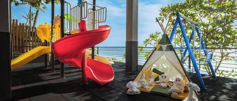 Un espace de jeux pour enfants avec des toboggans et une tente.