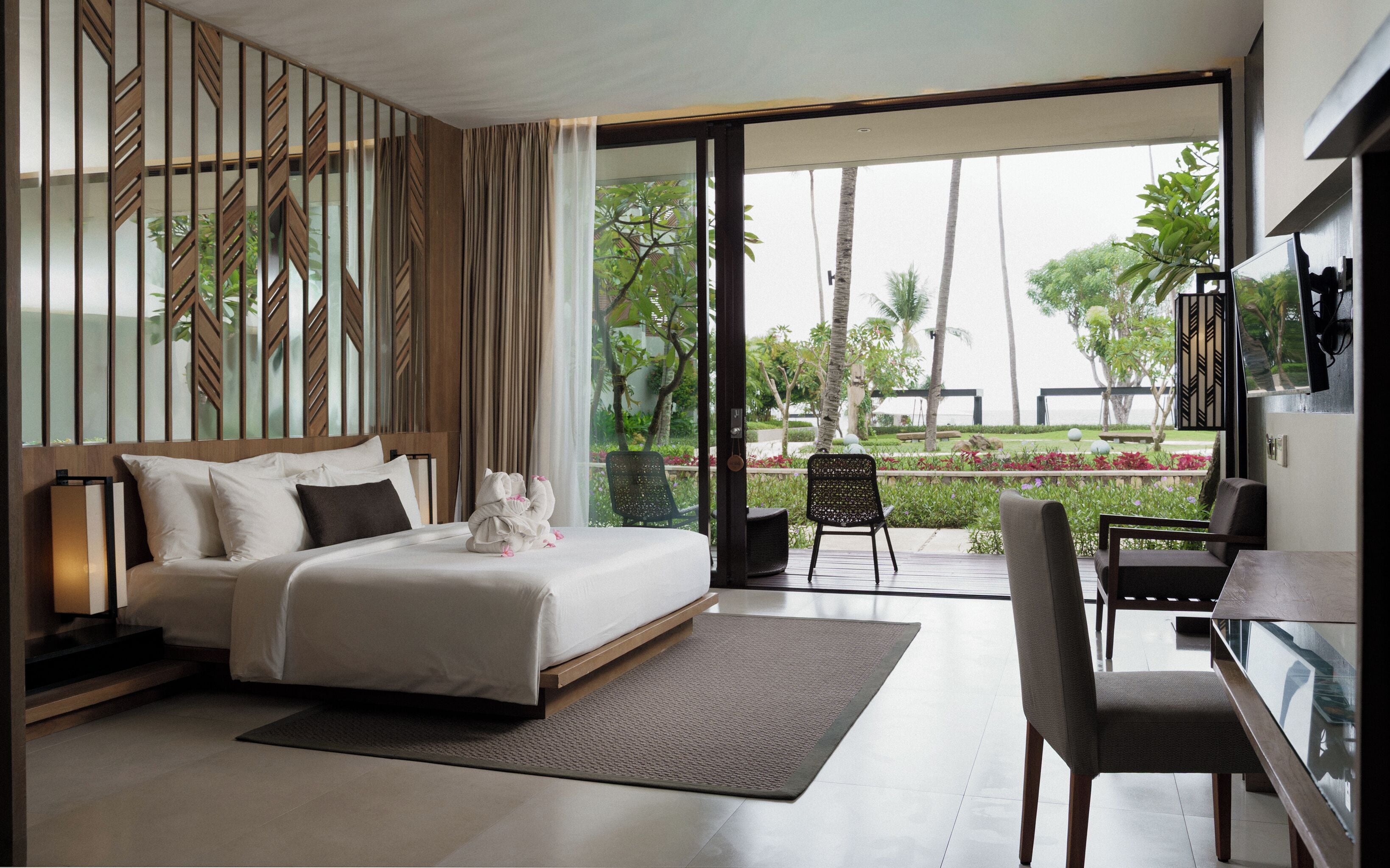 Una habitación de hotel moderna con cama, escritorio y vistas al exterior.