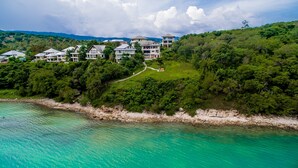 A coastal resort with multiple buildings, lush greenery, and a clear turquoise sea. - Villa Seven Swifts (Koh Samui)