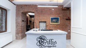 A reception desk with a white counter and a sign that reads "Ciflis". - Hotel Tiflis (Tbilisi)