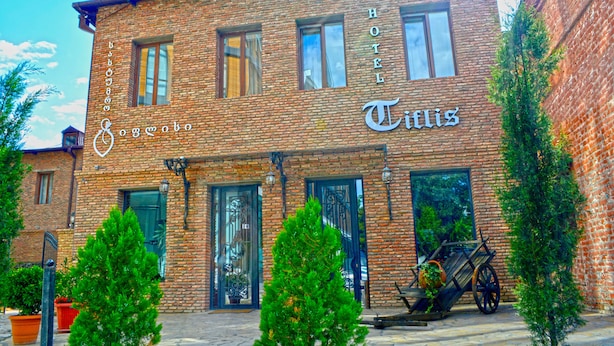 A brick building with a sign reading "Hotel Titis." - Hotel Tiflis (Tbilisi)
