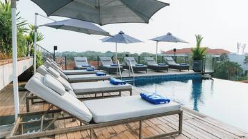 A poolside area with lounge chairs and umbrellas.