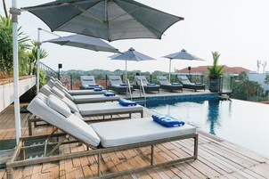 A poolside area with lounge chairs and umbrellas.