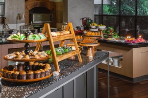 Un bufé con diferentes opciones de comida y una cocina al fondo.