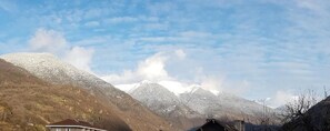 A mountainous landscape with snow-covered peaks and a clear sky.