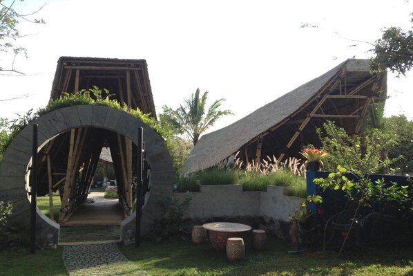 A rustic building with a thatched roof and a stone archway entrance. - Reewa Waree Resort (Pak Chong)