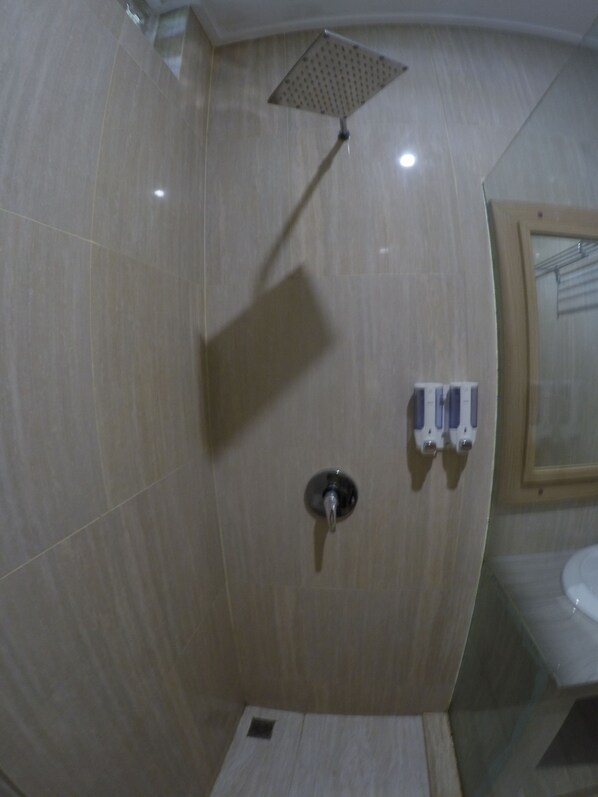 Une salle de bain avec une douche, des toilettes et un lavabo.