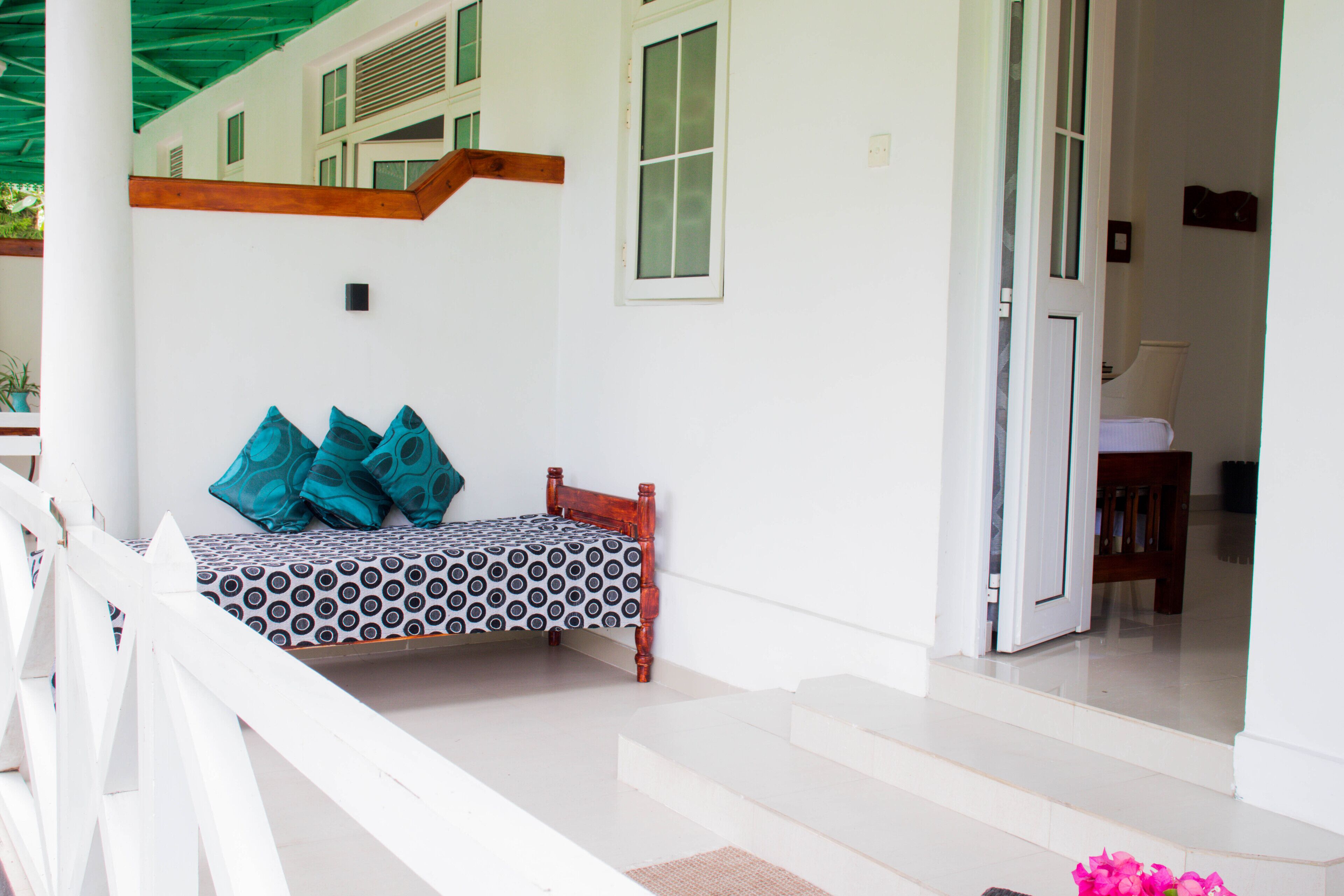 A room with a bed, a wooden bench, and a staircase leading to an upper level.